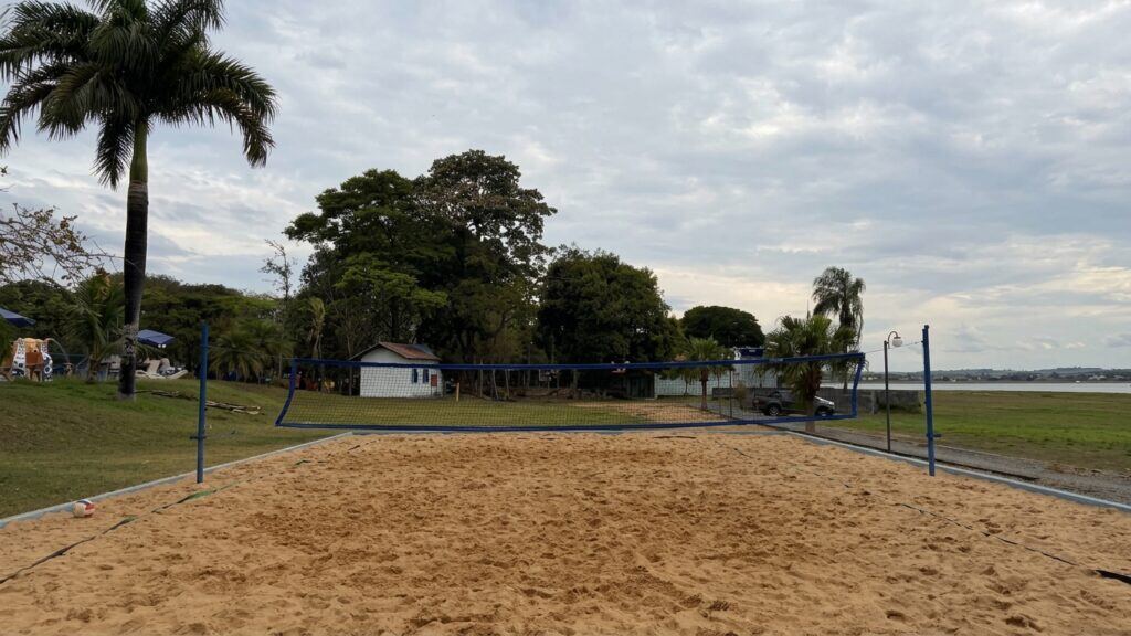 Quadras de areia do clube, entre as palmeiras e o lago