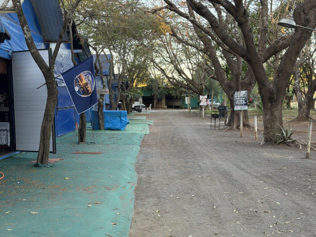 Rua entre as barracas dos sócios, sob as árvores