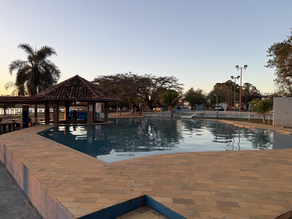 Piscina do clube ao entardecer, com quiosque ao lado