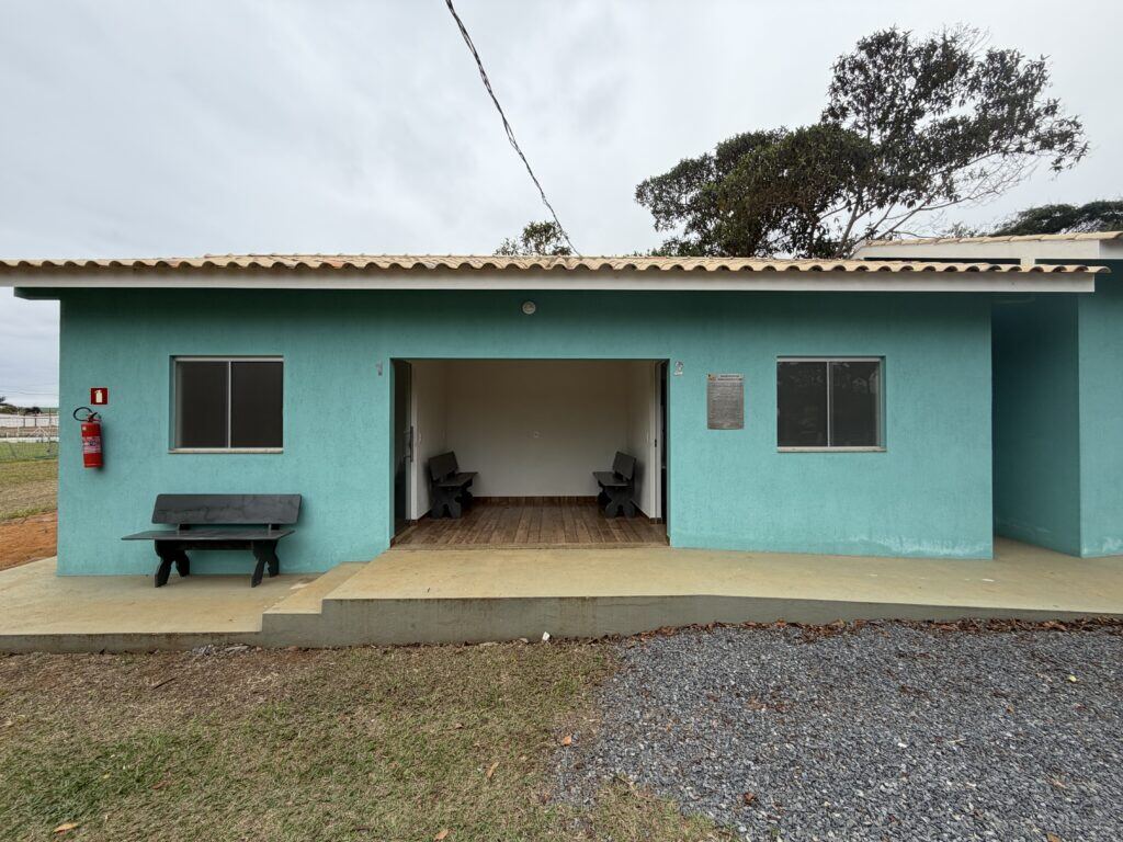 Chalé do clube com varanda coberta e bancos na entrada