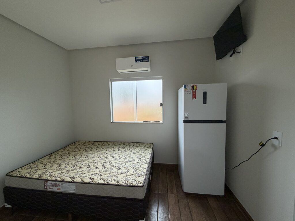 Quarto de chalé com cama de casal, ar-condicionado, frigobar e televisão