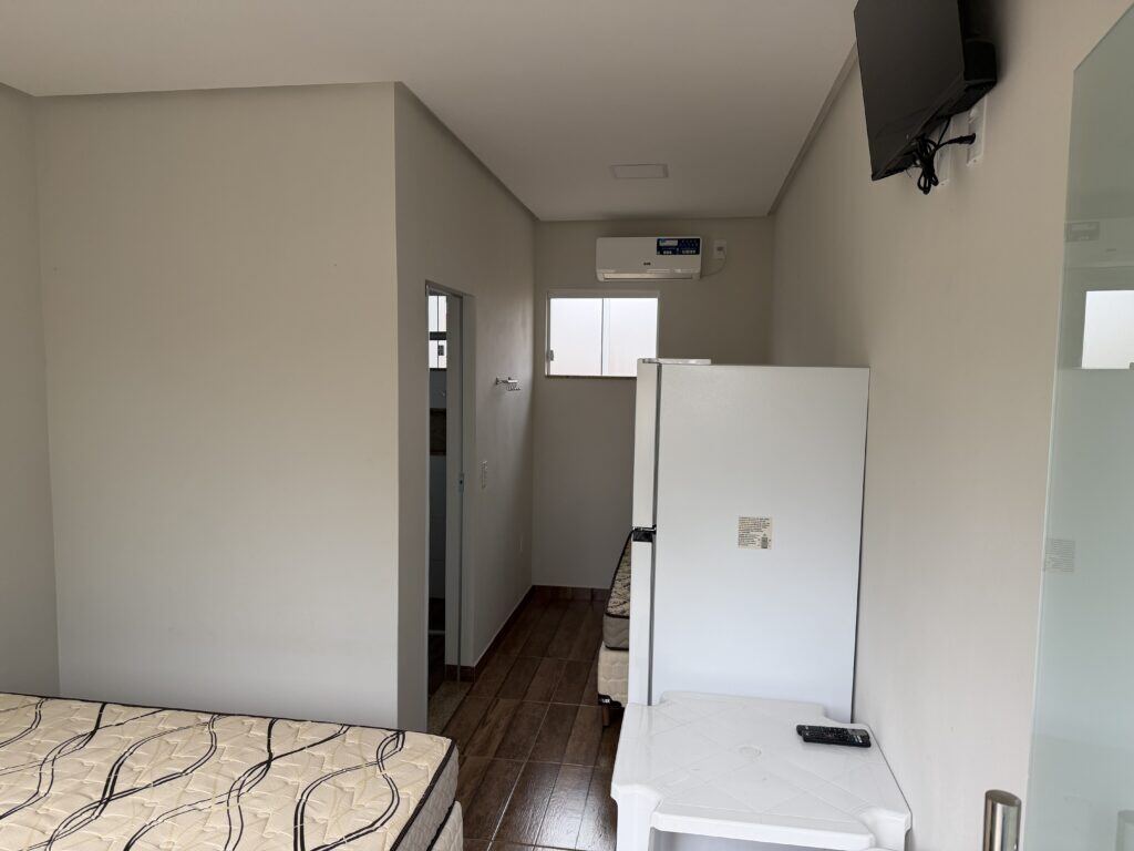 Quarto de chalé com duas camas, ar-condicionado, televisão, frigobar e acesso ao banheiro