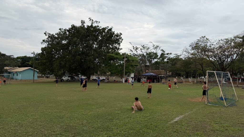 Campo de futebol gramado do clube, com trave e jogadores